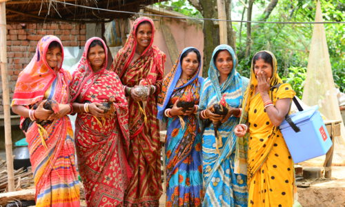 Women holding chickens
